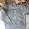 Sudadera Gris Con Inicial Flores Turquesa